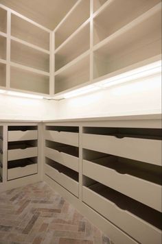 there are many shelves in the room that have drawers on each side and one is empty