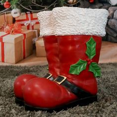 a pair of red boots sitting on top of a rug next to a christmas tree