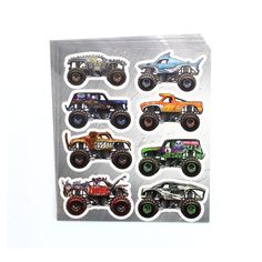 a pack of monster trucks stickers on top of a white surface with an orange and green truck in the middle