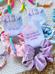 two purple and pink hair ties on top of a woven mat next to other items