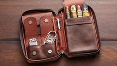 an open leather case with scissors and other items inside on a wooden table, top view