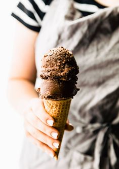 a woman holding an ice cream cone in her hand