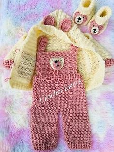 a pink knitted baby outfit with teddy bears on it