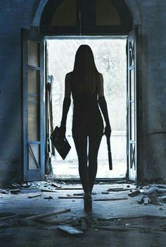 a woman walking into an open doorway with her handbag in her other hand and the light shining on her