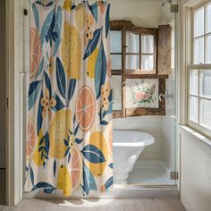 a bathroom with a shower curtain that has oranges on it