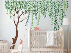 a baby's room with a tree and wall decals