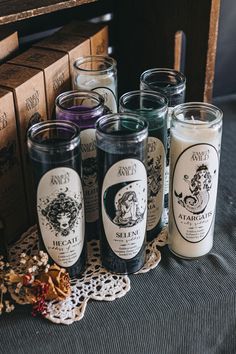 several candles sitting on top of a doily next to some boxes and paper tags