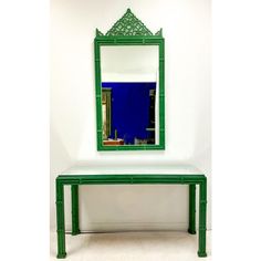 a green bench with a mirror on it and a white wall in the back ground