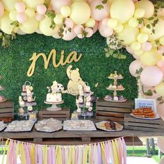 a winnie the pooh birthday party with balloons and desserts