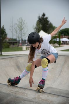 a young woman riding a skateboard down the side of a ramp