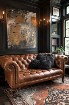 a brown leather couch sitting in front of a window next to a rug and lamp