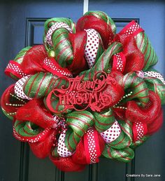 a red and green mesh wreath with the word merry christmas on it's front door