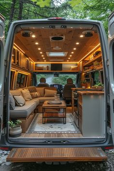 the interior of an rv with couches, tables and kitchen area in the back