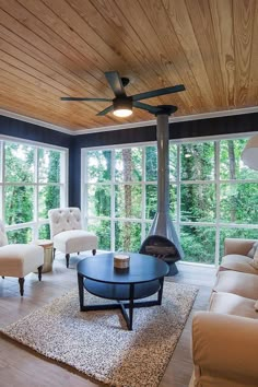 a living room with couches, chairs and a fire place in the middle of it