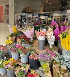 a bunch of flowers that are sitting on a table in front of some kind of store