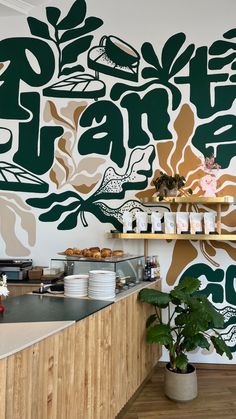 a wall painted with flowers and leaves in a kitchen area next to a counter top