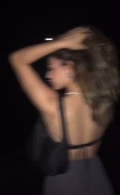 a blurry photo of a woman with her hair blowing in the wind at night