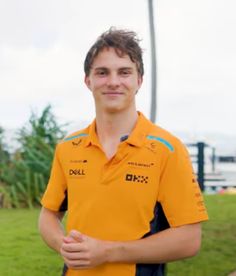 a young man in an orange shirt is posing for the camera