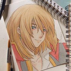 a drawing of an anime character with blonde hair and blue eyes on a spiral notebook