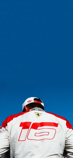 a man sitting on top of a snowboard next to a blue sky in the background