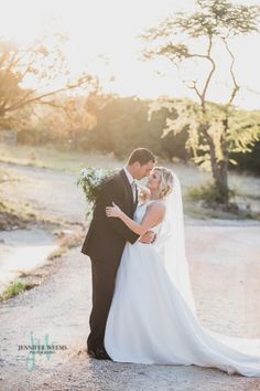 a bride and groom pose for a photo in front of the sun on their wedding day