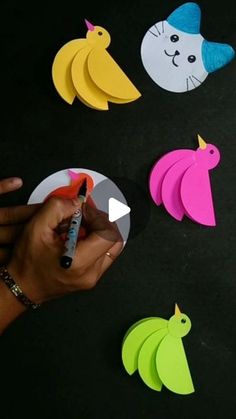 a person is writing on some paper with scissors and markers in front of several cut out animals