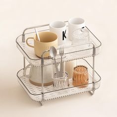 two tiered trays with cups and spoons on them, one holding a coffee mug