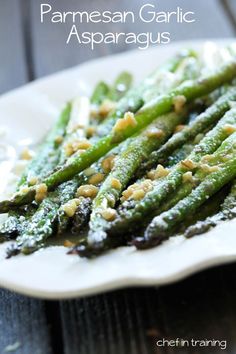 asparagus with parmesan cheese and seasoning on a white platter