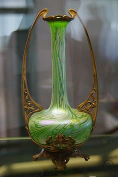 a green glass vase sitting on top of a table