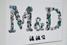 the word wed is made out of paper and beads on a white background with black lettering