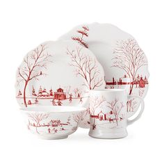 a red and white dinnerware set with winter scene on the plates, cups and saucers