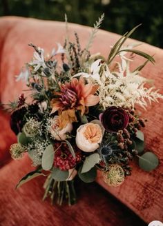 a bouquet of flowers sitting on top of an orange chair