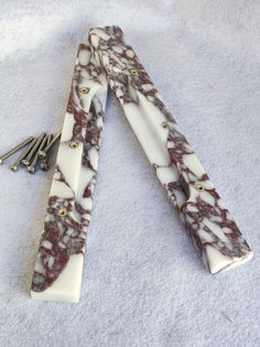 two white and brown marbled items laying on top of each other with gold accents