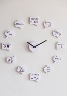 a clock made out of white paper with numbers and speech bubbles on the face that read high noon