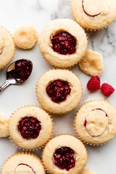 several raspberry muffins on a marble surface