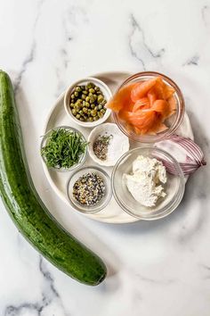 a cucumber sitting on top of a white plate next to other ingredients