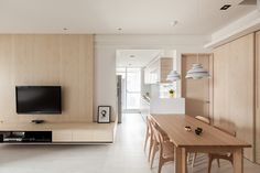 a living room with wooden furniture and a flat screen tv mounted to the side of a wall