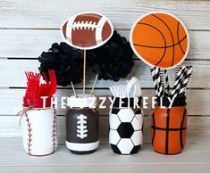 there are sports themed items in the vases on the table, along with tissue pom poms