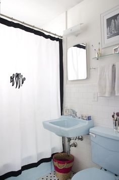 a bathroom with a sink, toilet and shower curtain in black and white color scheme