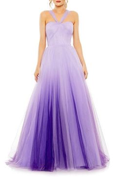 a woman in a long purple dress with a halter top and tulle skirt