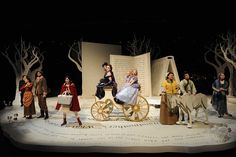 a group of people sitting on top of a stage with horses and carriages in front of them