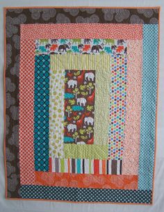 a quilted wall hanging with elephants on it