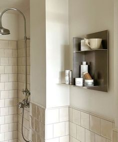 a bathroom with a shower head and shelves on the wall