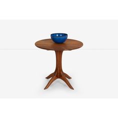 a small wooden table with a blue bowl on it's center and two legs