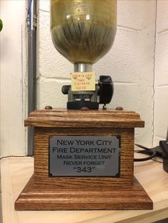 a fire department award is displayed on a wooden base with a sign that reads new york city fire department never forget