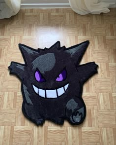 a black rug with purple eyes and fangs on it