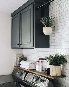 a washer and dryer sitting next to each other in a room with white tiles on the walls