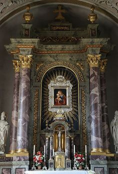 an ornate alter in a church with statues on either side and paintings on the wall