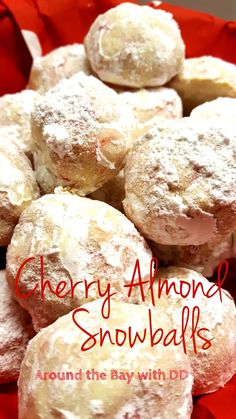 a pile of powdered sugar covered doughnuts sitting on top of a red cloth