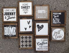 a group of wooden signs on the side of a building that says home, love, sweet home, feed me, and drink me